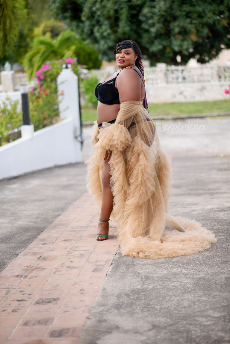 PLUS size black woman with box braids in a black velvet bra and panty set. She has on green heels and a luxe tulle sand color robe.