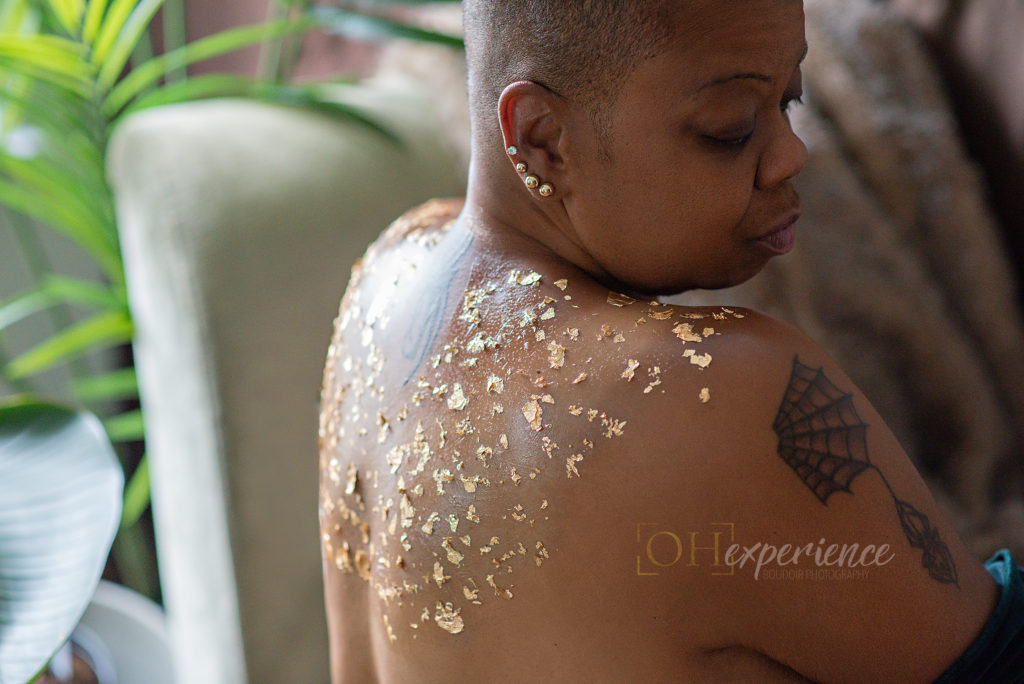 Black woman with gold foil applied to back. 