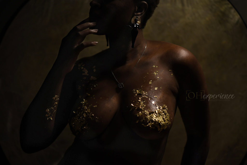 Black woman with gold leaf on her body and large earrings; Home by Areeayl earrings