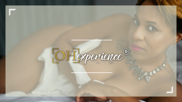 black woman wrapped in white sheet laying a bed, text: ohexperience